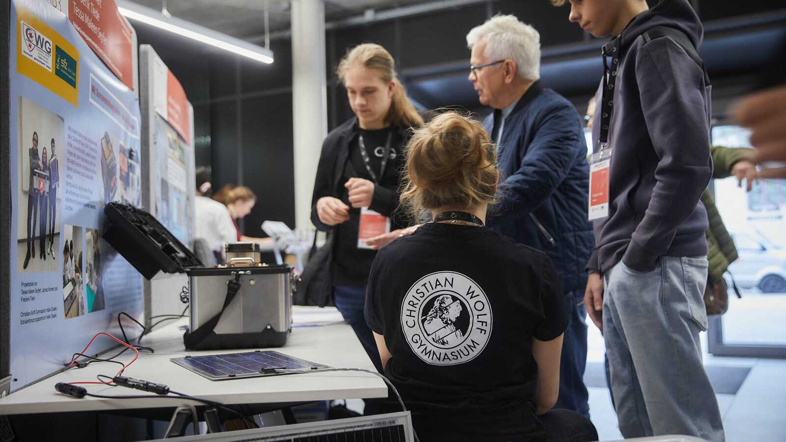 Team von Jungforschenden beim Aufbau ihres Standes