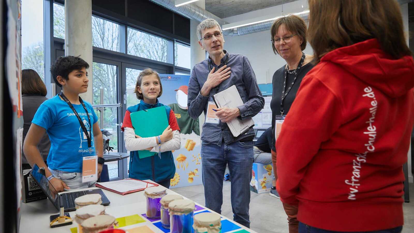 Jurymitglied im Gespräch am Stand mit Jungforschenden