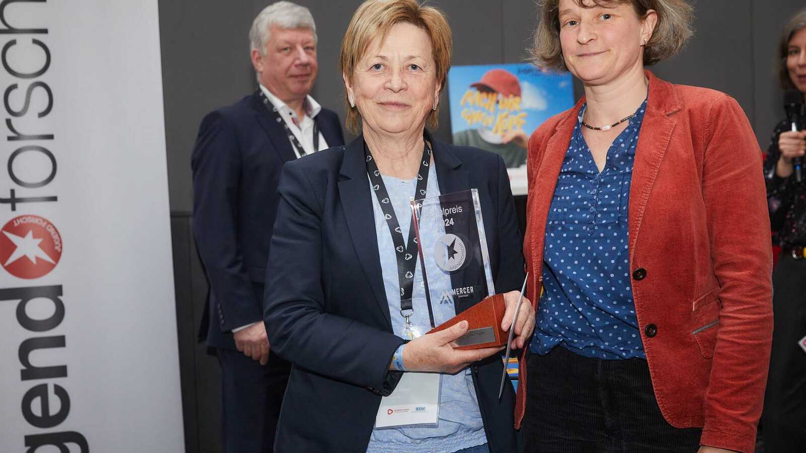 Der Pokal für die beste Jugend forscht Schule wird an eine Vertreterin des Schülerforschungszentrums Halle übergeben