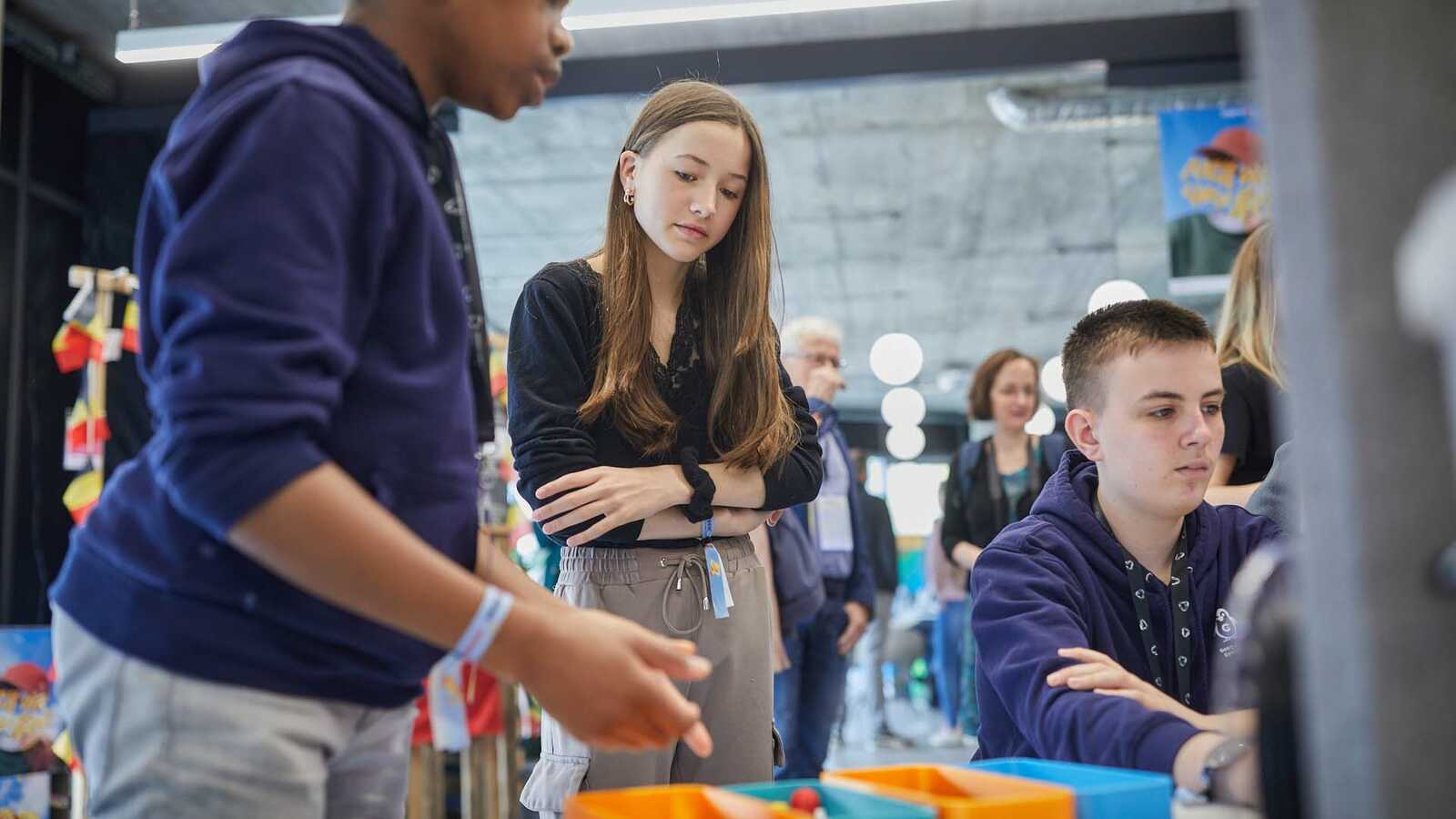 Menschen und Jungforschende an Ständen der Ausstellung im Gespräch